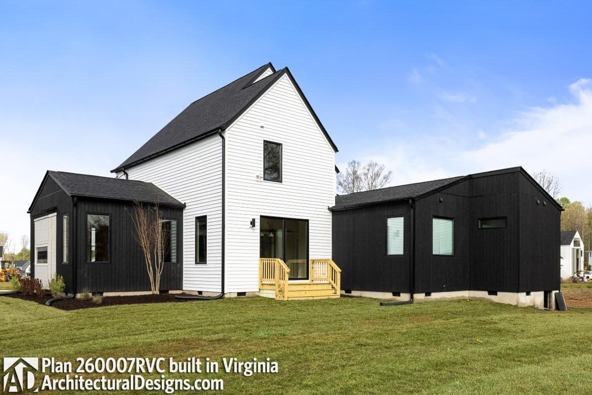 House plan exterior: Modern style, two stories, white vertical siding, black gables, deck with railing, and multiple attached volumes.