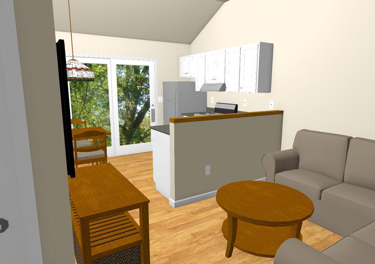 Open-concept living area with vaulted ceiling, featuring a kitchen with white cabinets and a living space with a sofa.