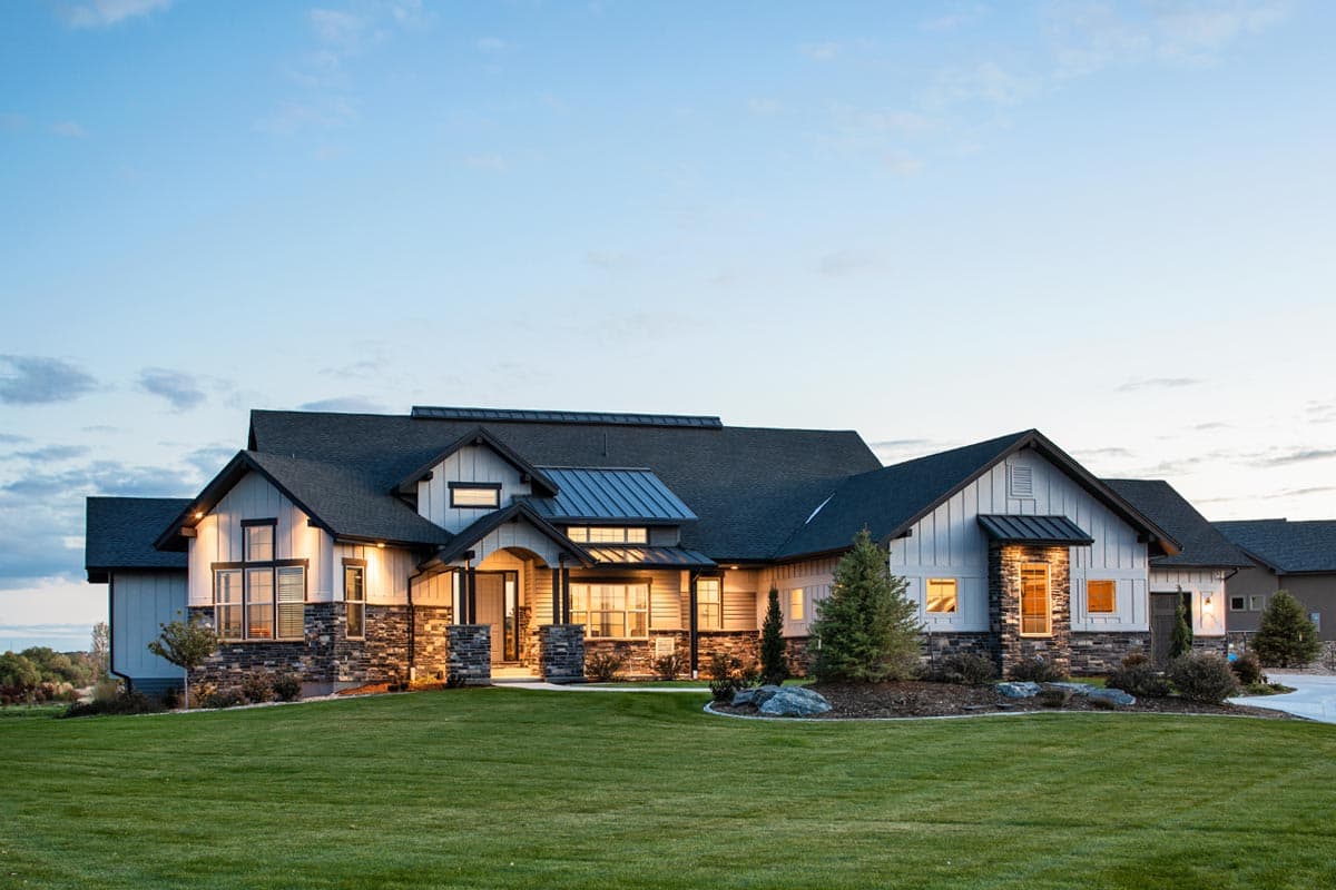Modern Farmhouse house plan exterior with multiple gables, stone accents, covered entry, and large windows.