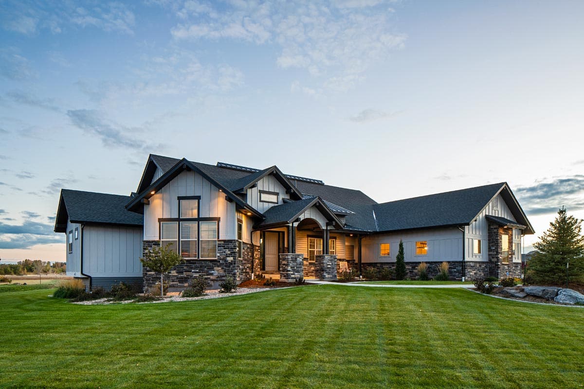 Modern Farmhouse house plan exterior with stone accents, board and batten siding, gables, and covered entry.
