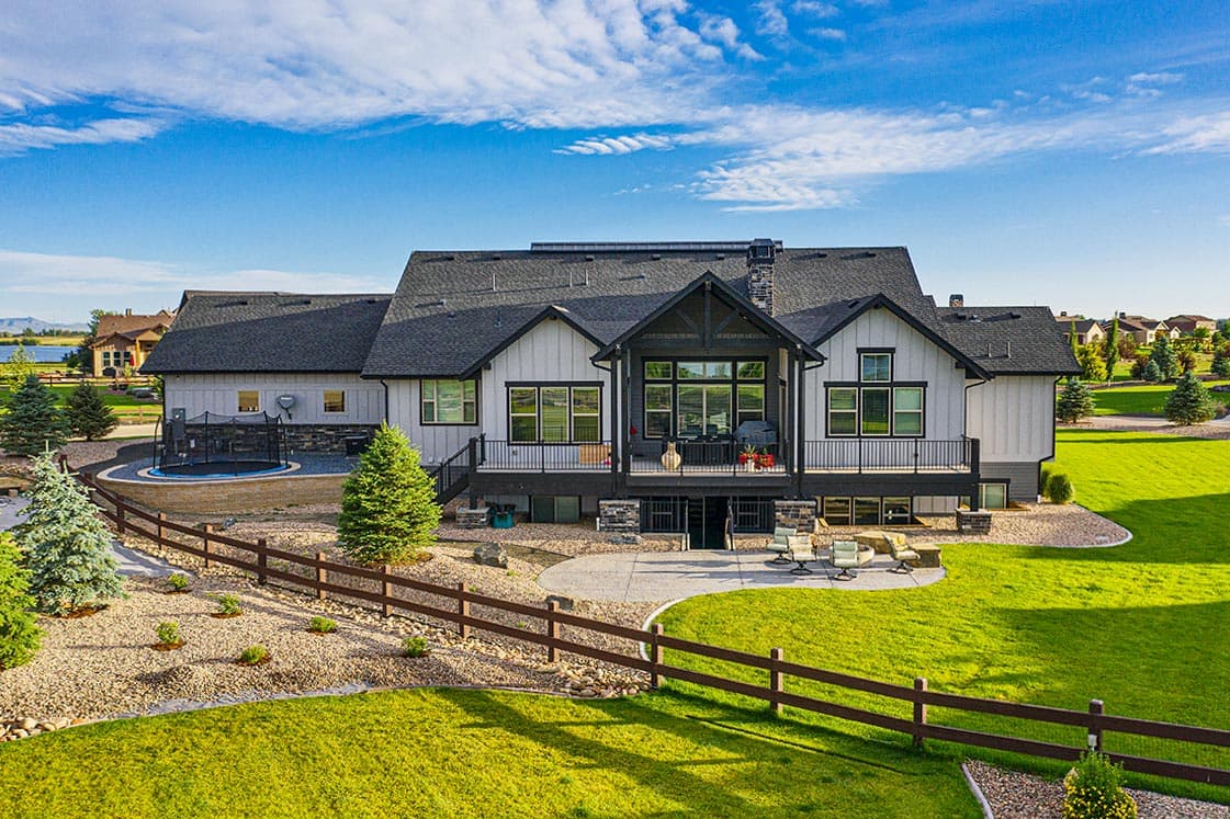 Modern Farmhouse house plan exterior with gabled roof, large windows, and a two-level deck.