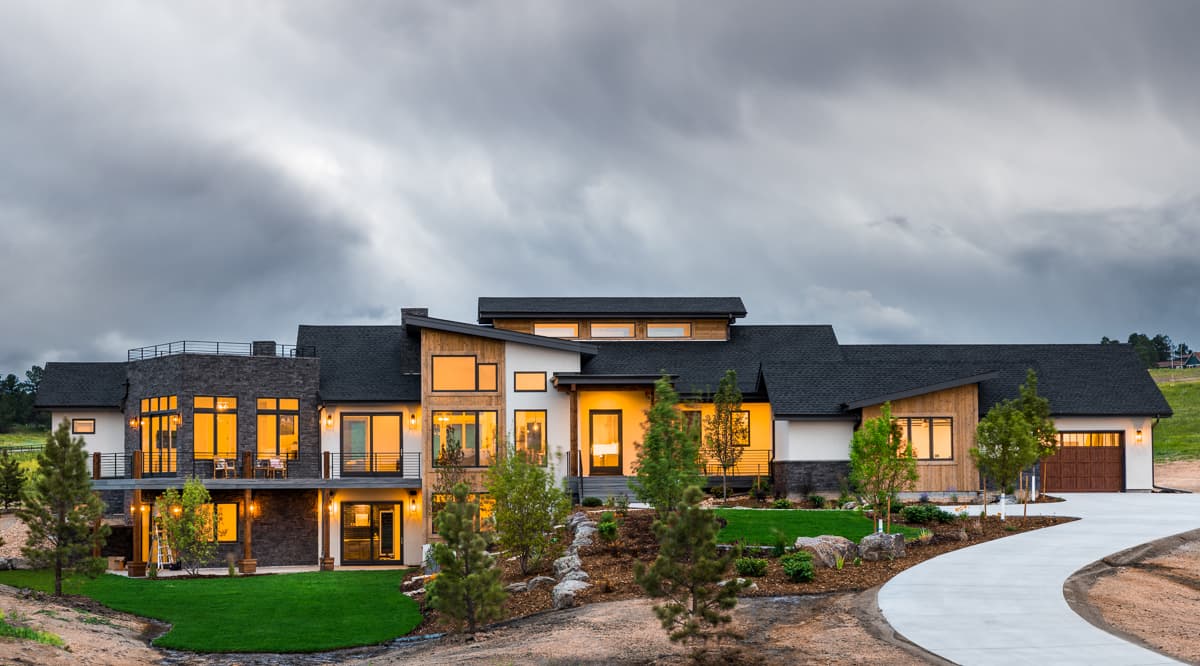 House plan exterior. Modern style, two-story home with flat and angled rooflines. Features include balcony, wood siding, and attached garage.