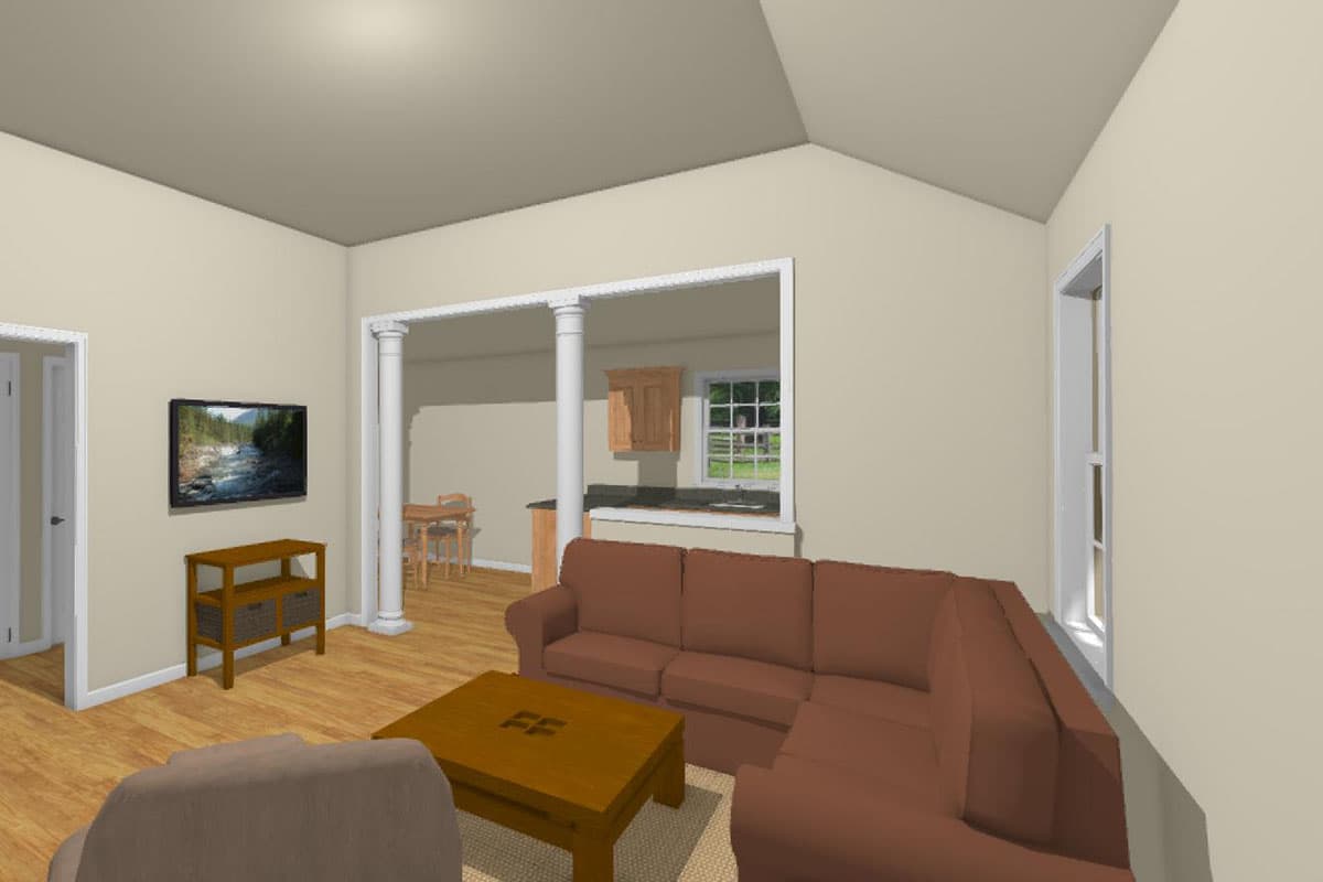Living area with vaulted ceiling, sectional sofa, coffee table, and view into kitchen with island.