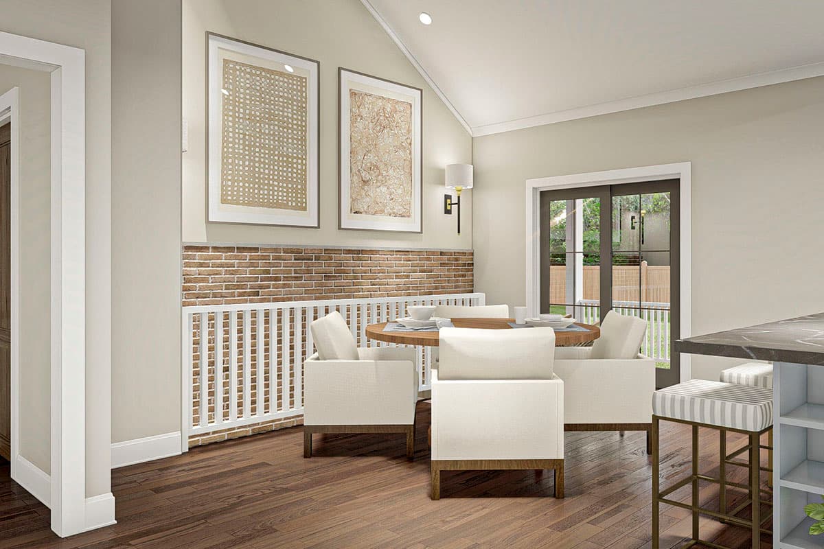 Dining area with vaulted ceiling, brick accent wall, and sliding glass doors to an outdoor space.