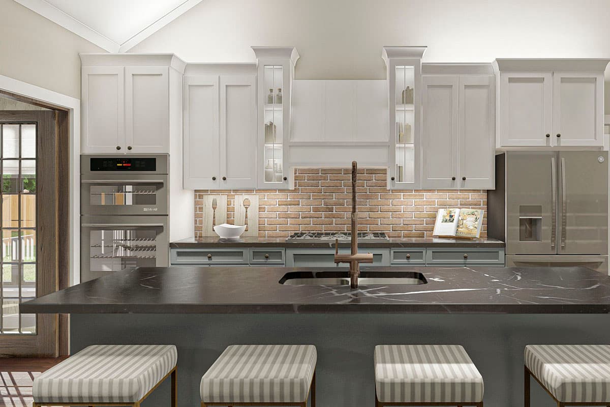Kitchen with white cabinets, brick backsplash, double ovens, stainless steel refrigerator, and large island with sink.