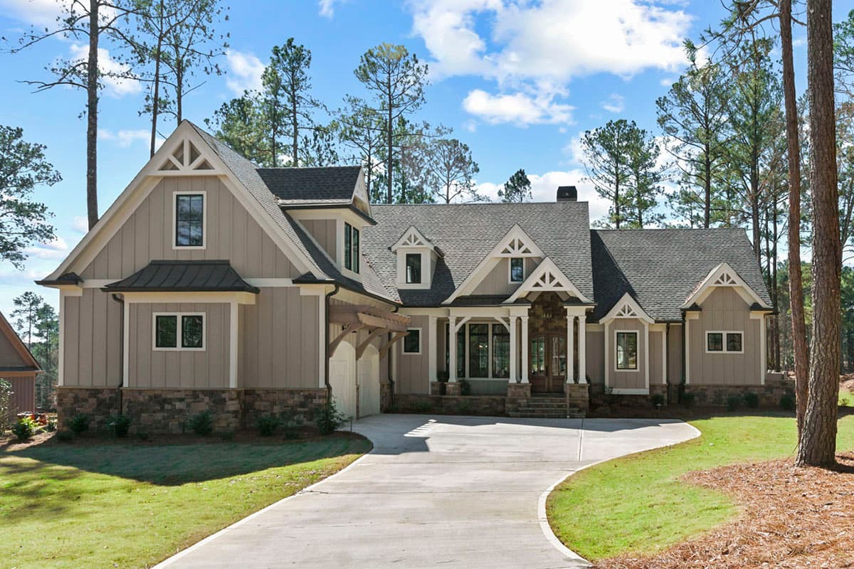 House plan exterior: Craftsman style, two stories, with gables, dormers, and a covered porch. Features stone facade and garage.