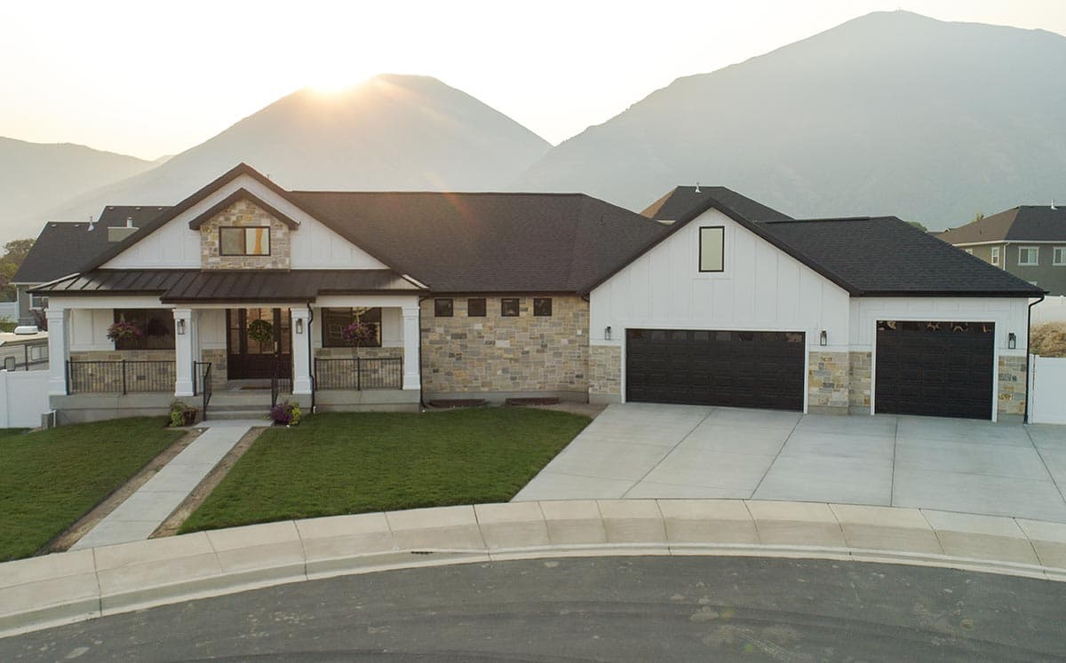 Modern Farmhouse style house plan exterior with a covered porch, stone accents, and a three-car garage.