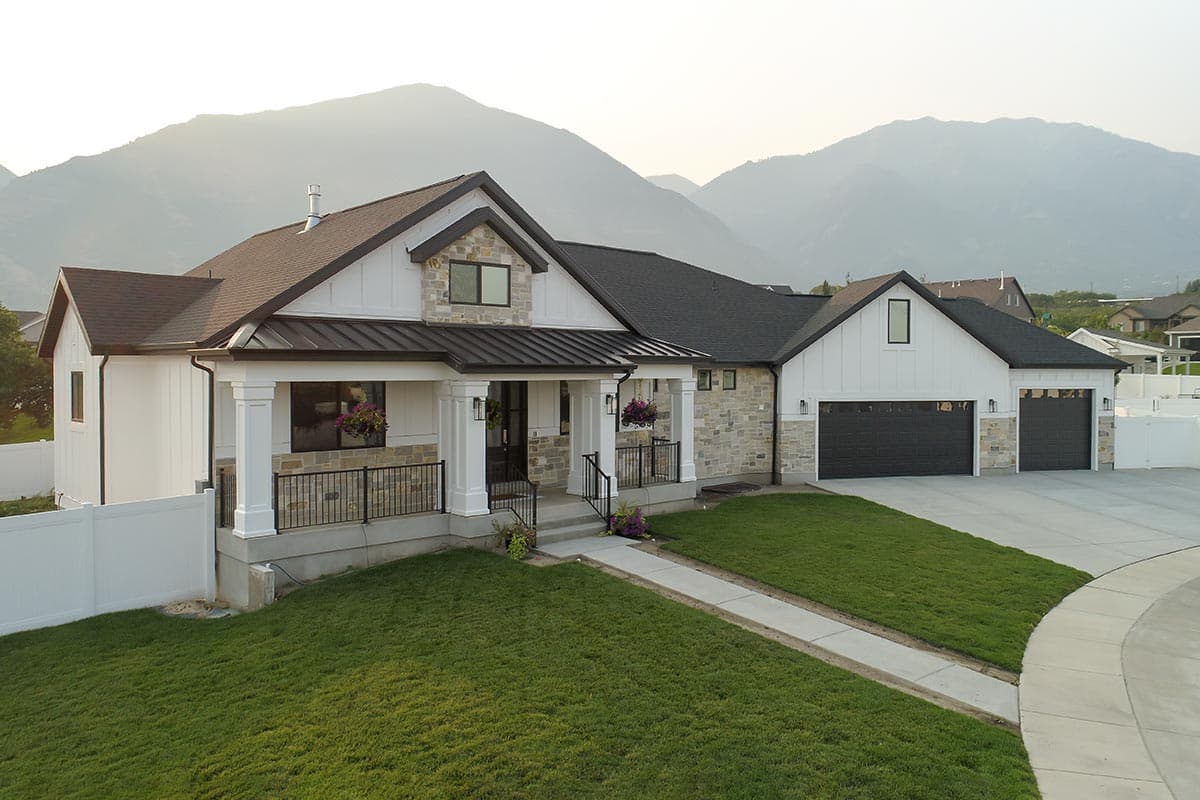 Modern Farmhouse house plan exterior, one story, with a covered front porch, stone and board-and-batten siding, and a three-car garage.