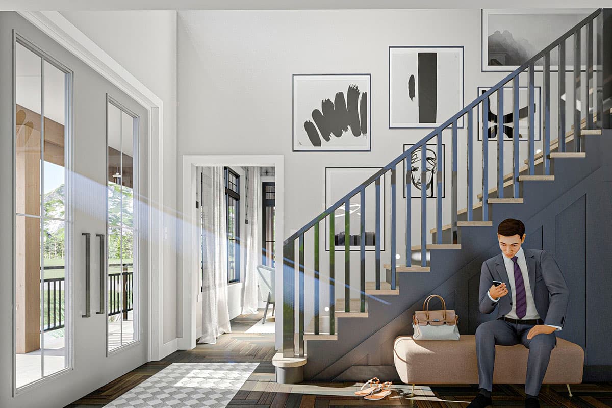 Interior view of a house entry with a staircase, bench, double doors, and artwork. A man sits on the bench.