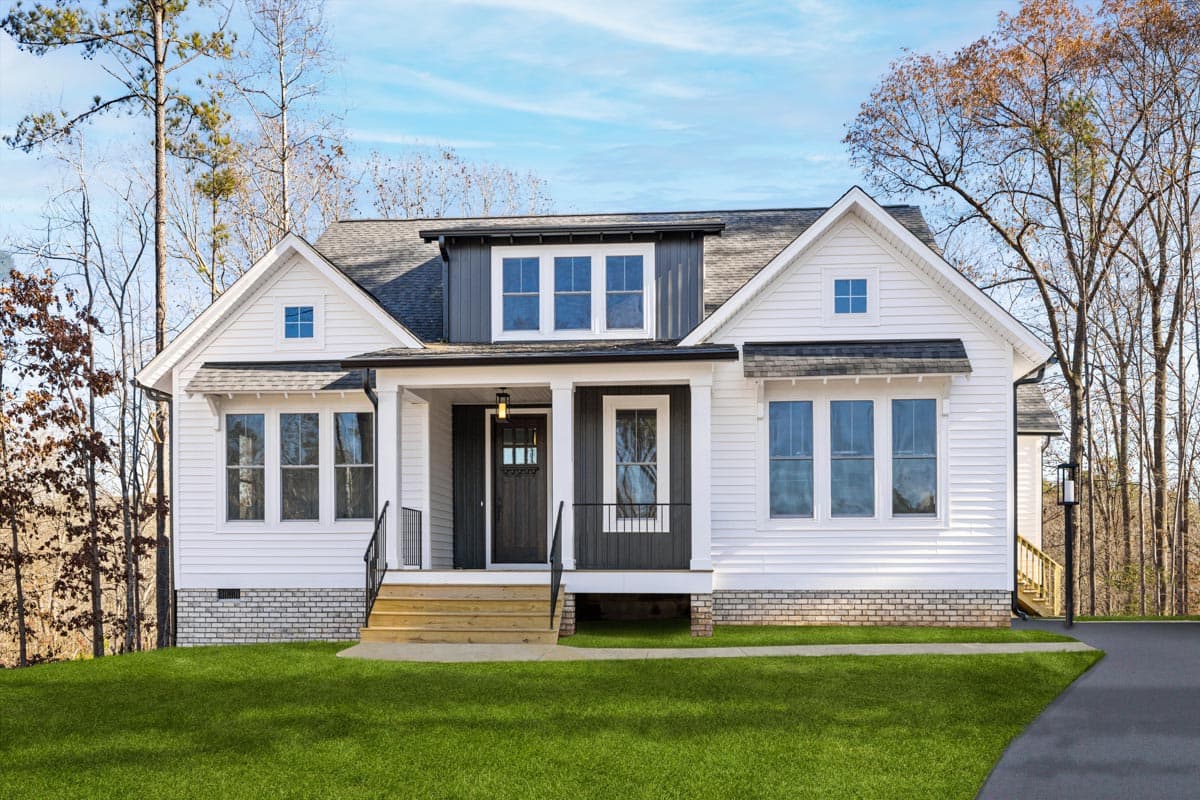 House plan exterior: Two-story Modern Farmhouse with gable dormers, covered front porch, and a dark wood front door.