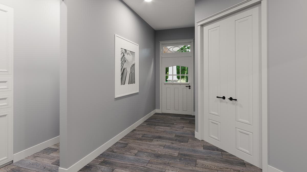 Interior view of a hallway with a paneled door and a framed picture on the wall.