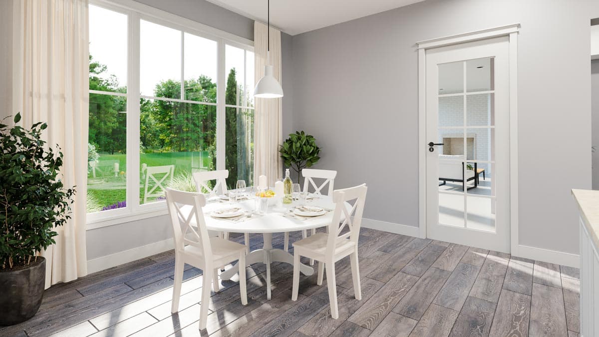 Dining area with round table, cross-back chairs, large windows, and French door leading to living room.