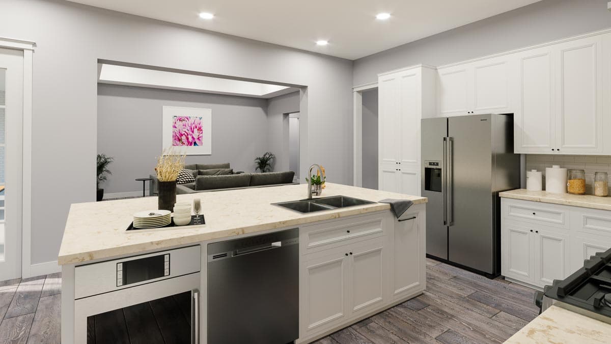 Kitchen with an island featuring a double sink, dishwasher, and microwave. Stainless steel refrigerator and white cabinetry.