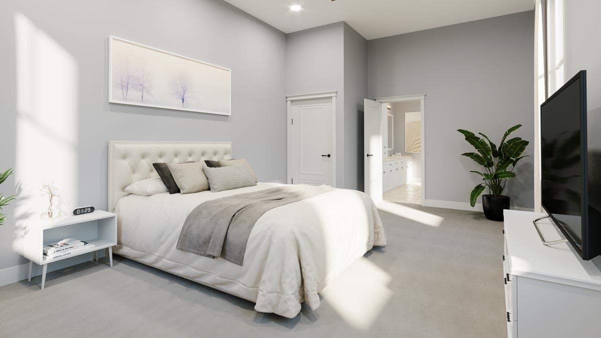 Primary bedroom with tufted headboard, cathedral ceiling, and adjoining bathroom with double vanity.