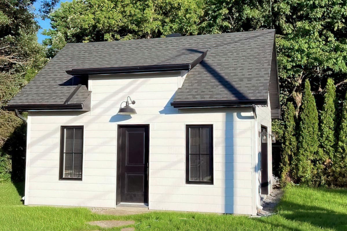 House plan exterior: Two-story modern home with hip roof, gables, and large windows.