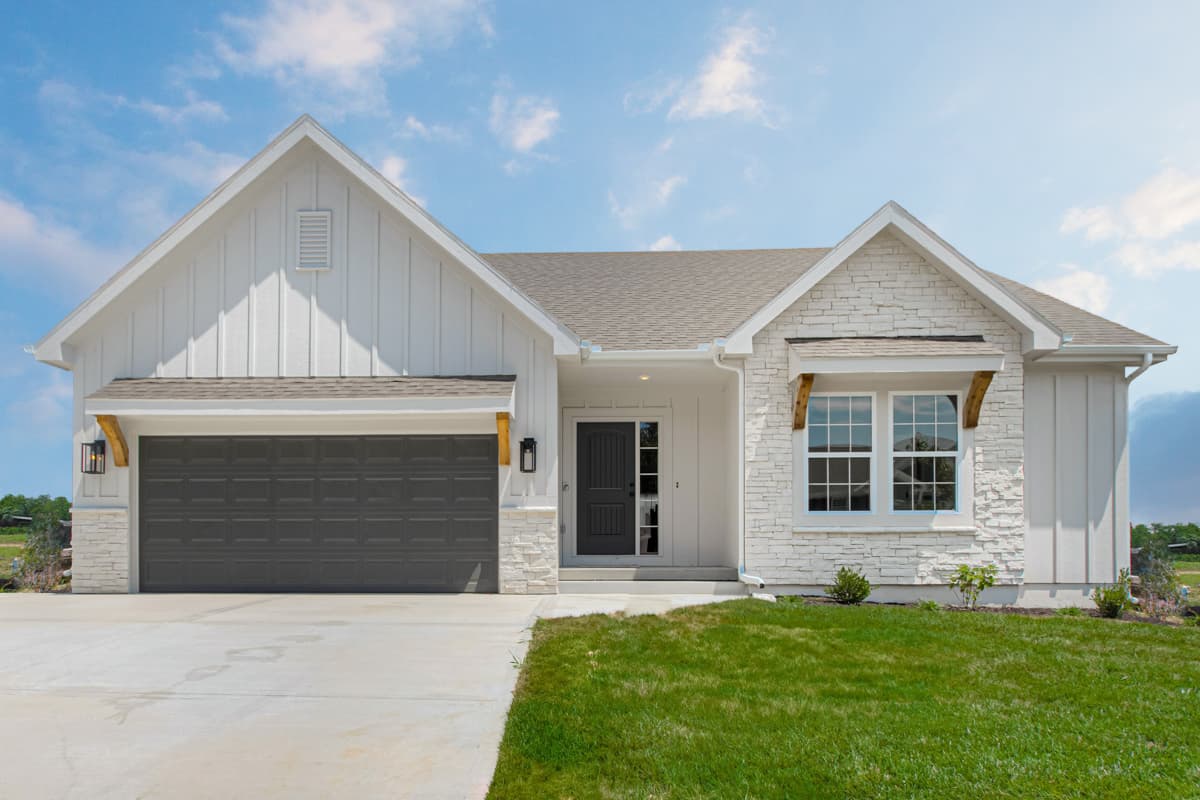 Modern Farmhouse style house plan exterior with board and batten siding, stone accents, front-facing garage, and covered entry.