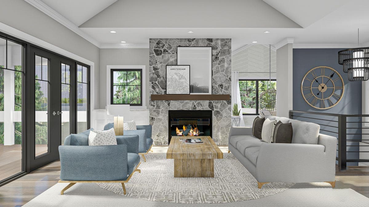 Living room with stone fireplace, wood mantel, gray sofa, blue chairs, wooden coffee table, and double doors to deck.