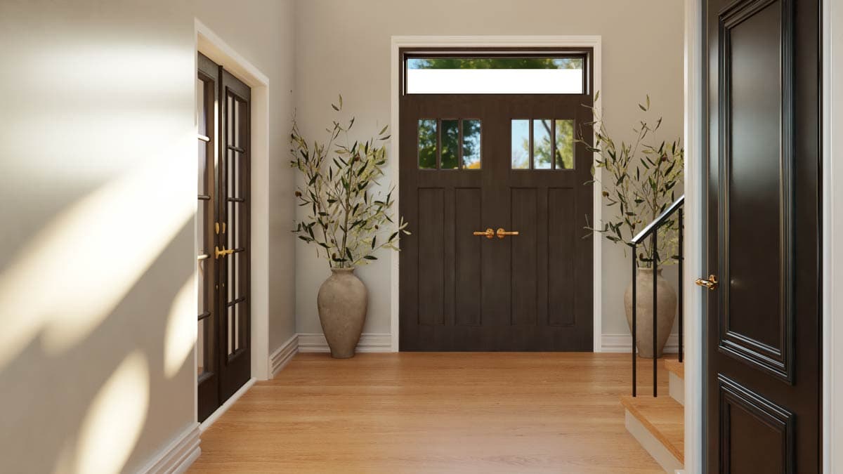 Interior view of entryway with dark wood paneled doors, a transom window, and a vase with olive branches.