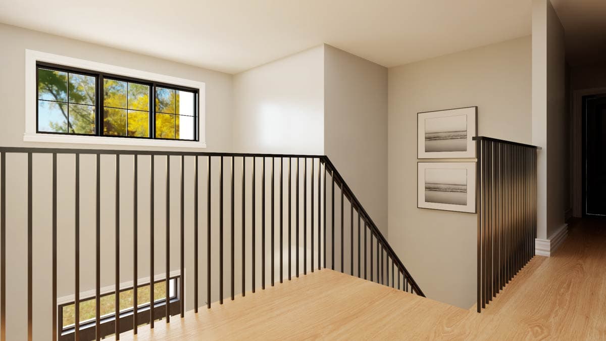 Interior hall with a long horizontal window, wood flooring, and black metal railings on a staircase.