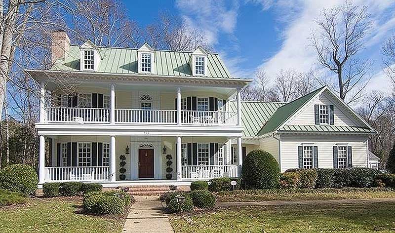 House plan exterior: two-story home with double porches, dormer windows, and a gabled section.
