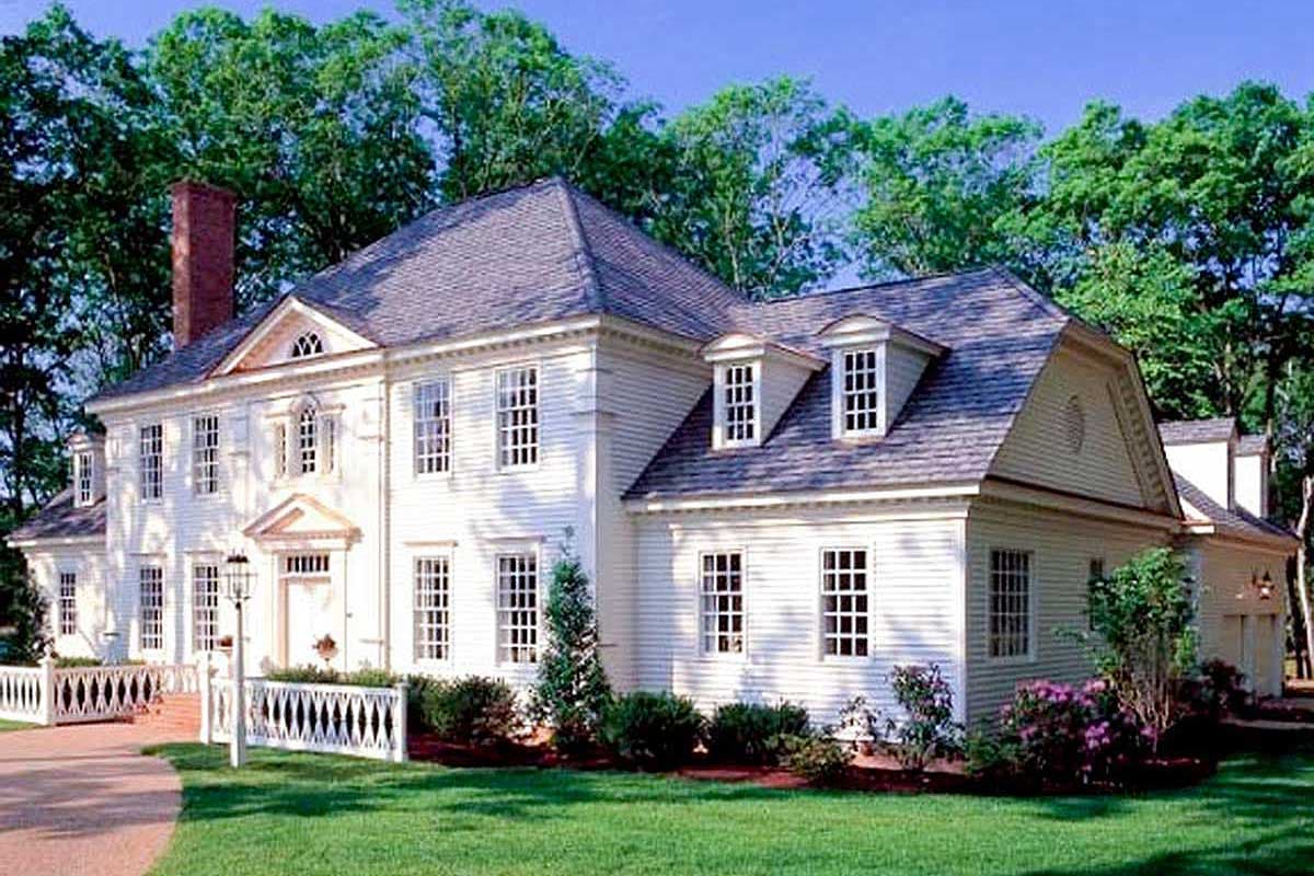 House plan exterior. Colonial style two-story home with dormers, symmetrical facade, and a hipped roof. Features a brick chimney.