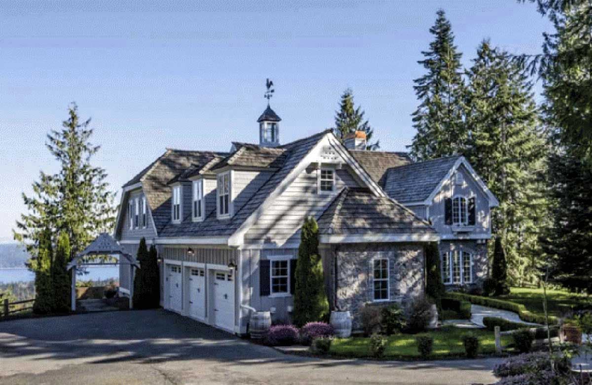 House plan exterior with a dormer, multiple gables, cedar shake roof, and a four-car garage.