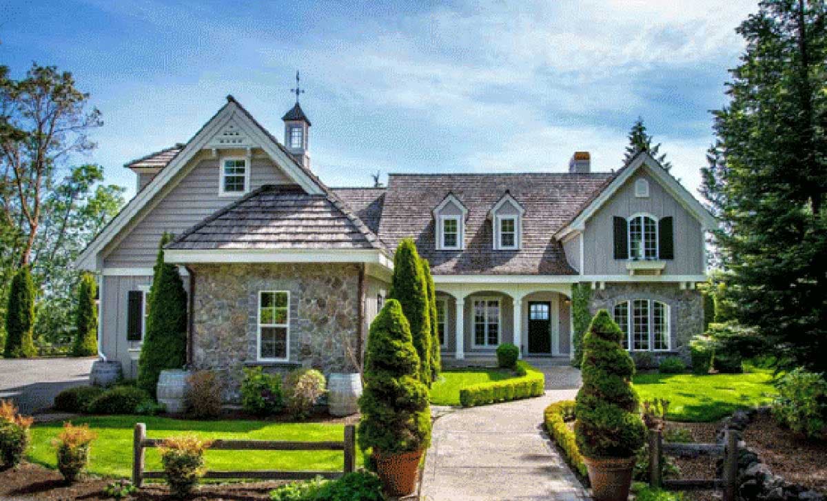 House plan exterior with stone accents, wood shake roof, and dormers. Features include a front porch with columns and multiple gabled rooflines.