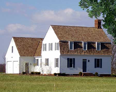 Colonial Revival house plan exterior with attached garage, symmetrical facade, dormer windows, and brick chimney.