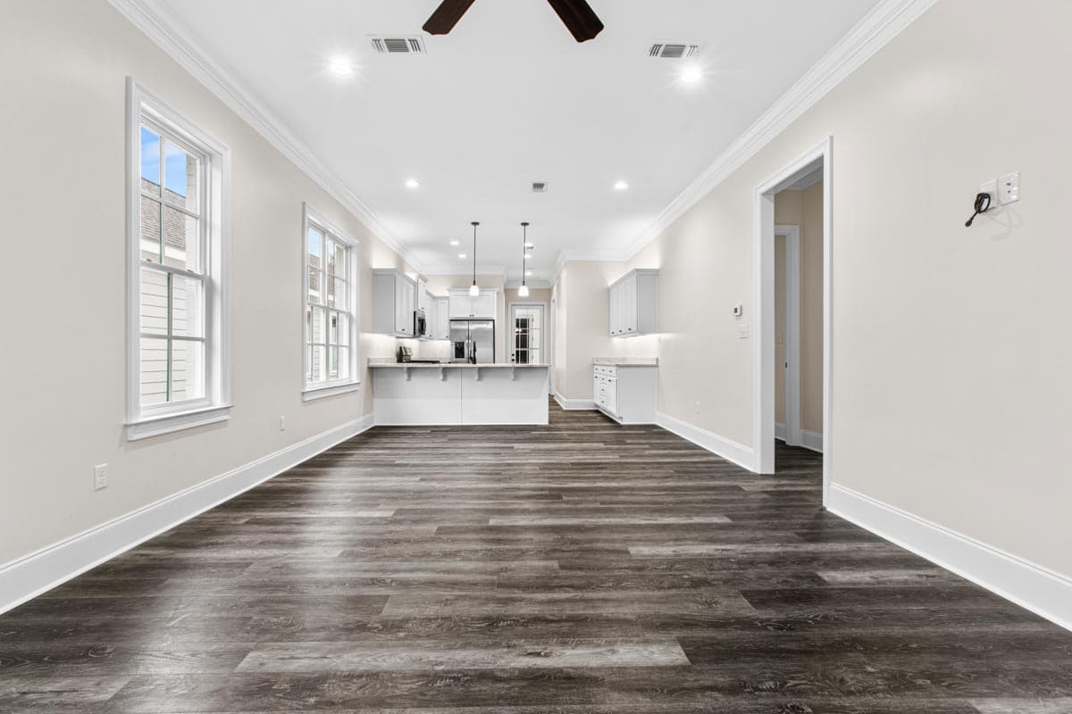 Interior view of an open-concept living area with a modern kitchen, featuring a central island and stainless steel appliances.