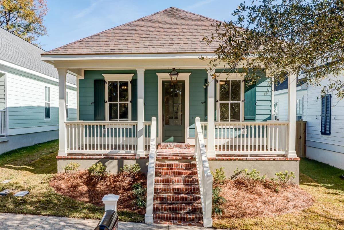 House plan exterior. One-story Cottage style with a front porch, gabled roof, and brick steps leading to the entry door.