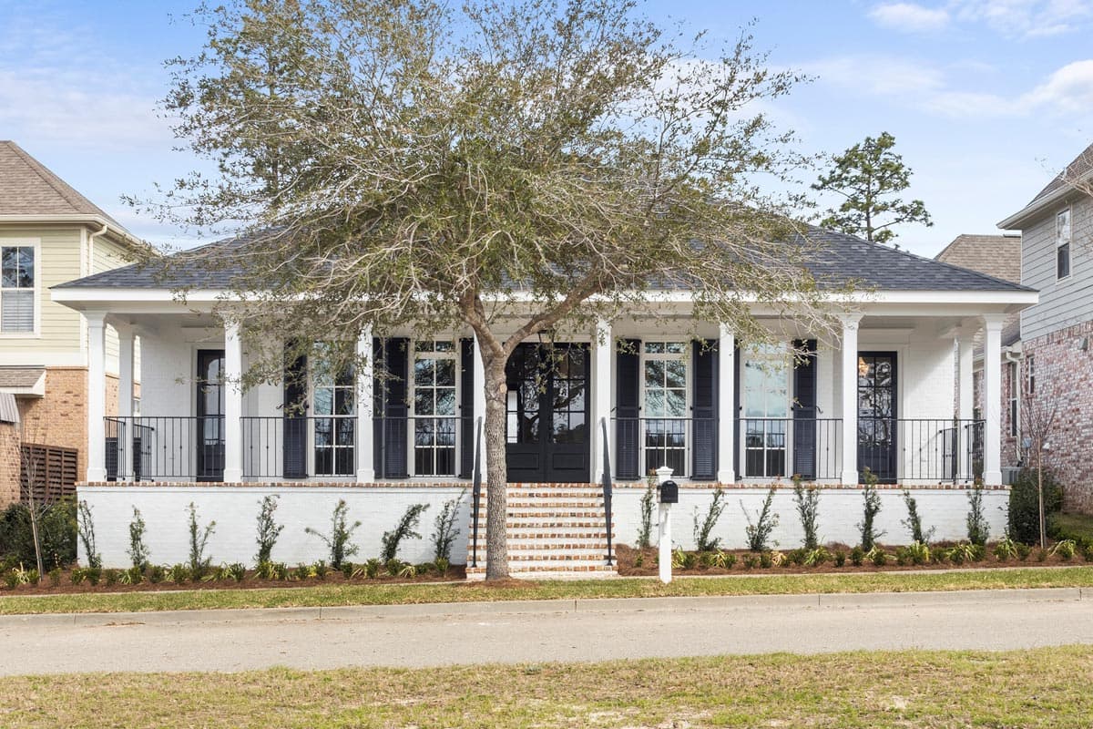 House plan exterior: One-story Modern Farmhouse with wraparound porch, white brick base, black shutters, and metal railings.