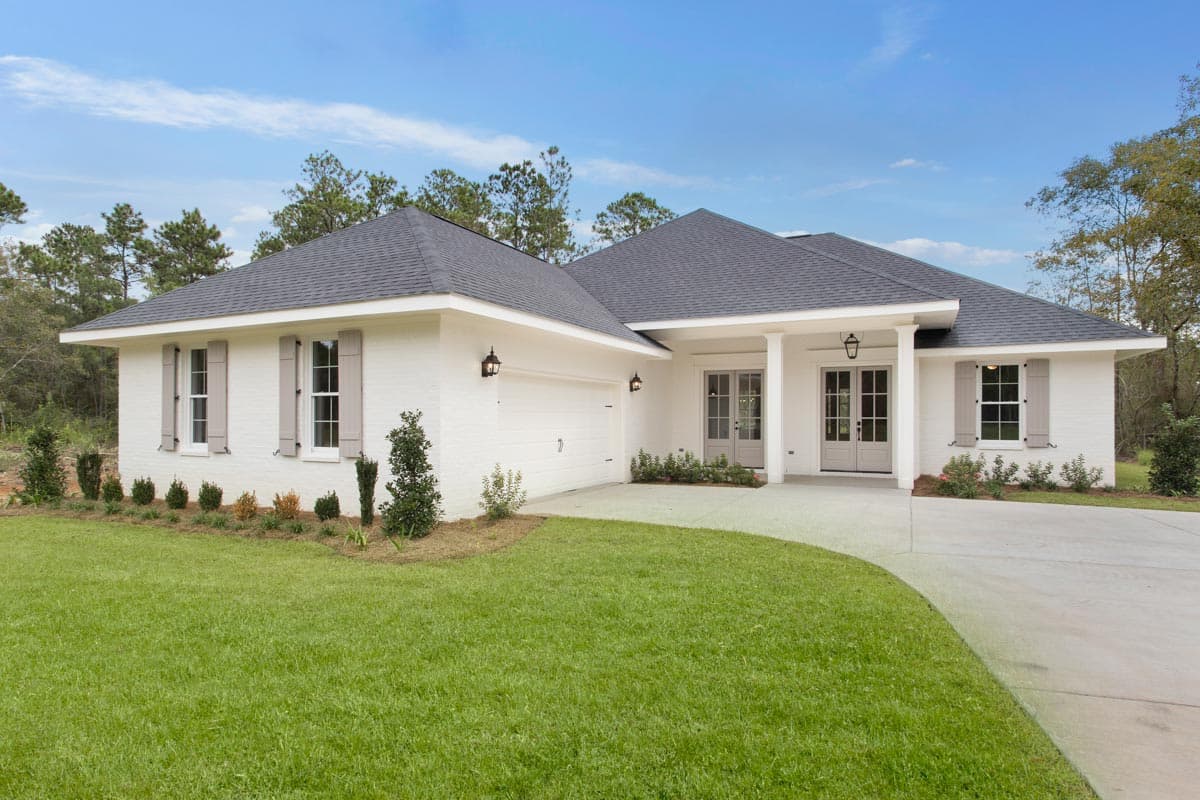 House plan exterior. One-story Ranch style. Features include gabled roof, covered porch with columns, and attached garage. Includes shutters.