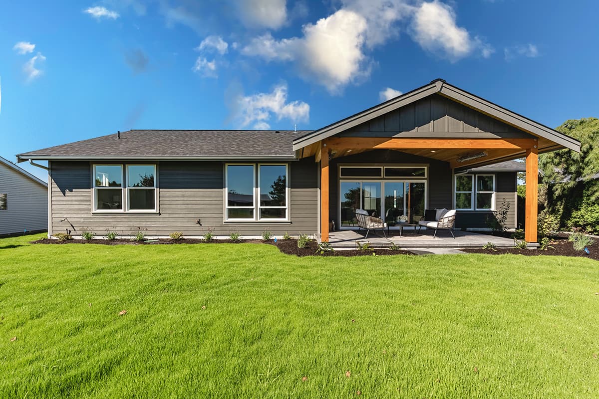 House plan exterior: Ranch-style, single-story with covered patio, large windows, and wood beam accents.