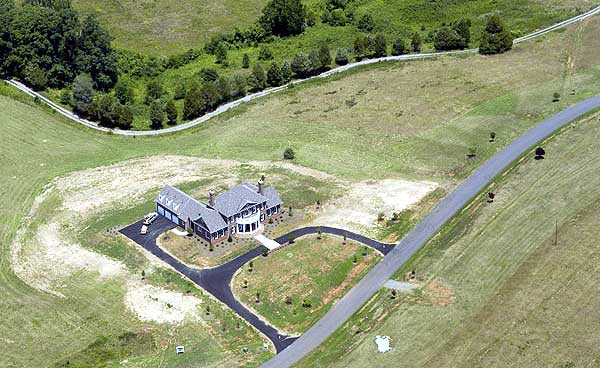 House plan exterior of a two-story home with a side-entry garage and prominent curved entryway.