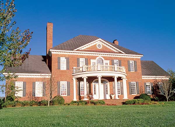 House plan exterior: two-story brick home with a rounded portico, second-story balcony, and prominent chimney.