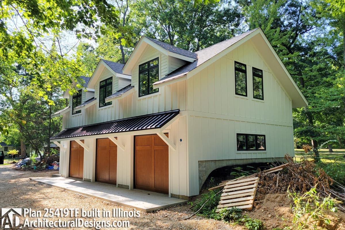 Modern Farmhouse house plan exterior with three garage doors, white board and batten siding, and multiple gables.