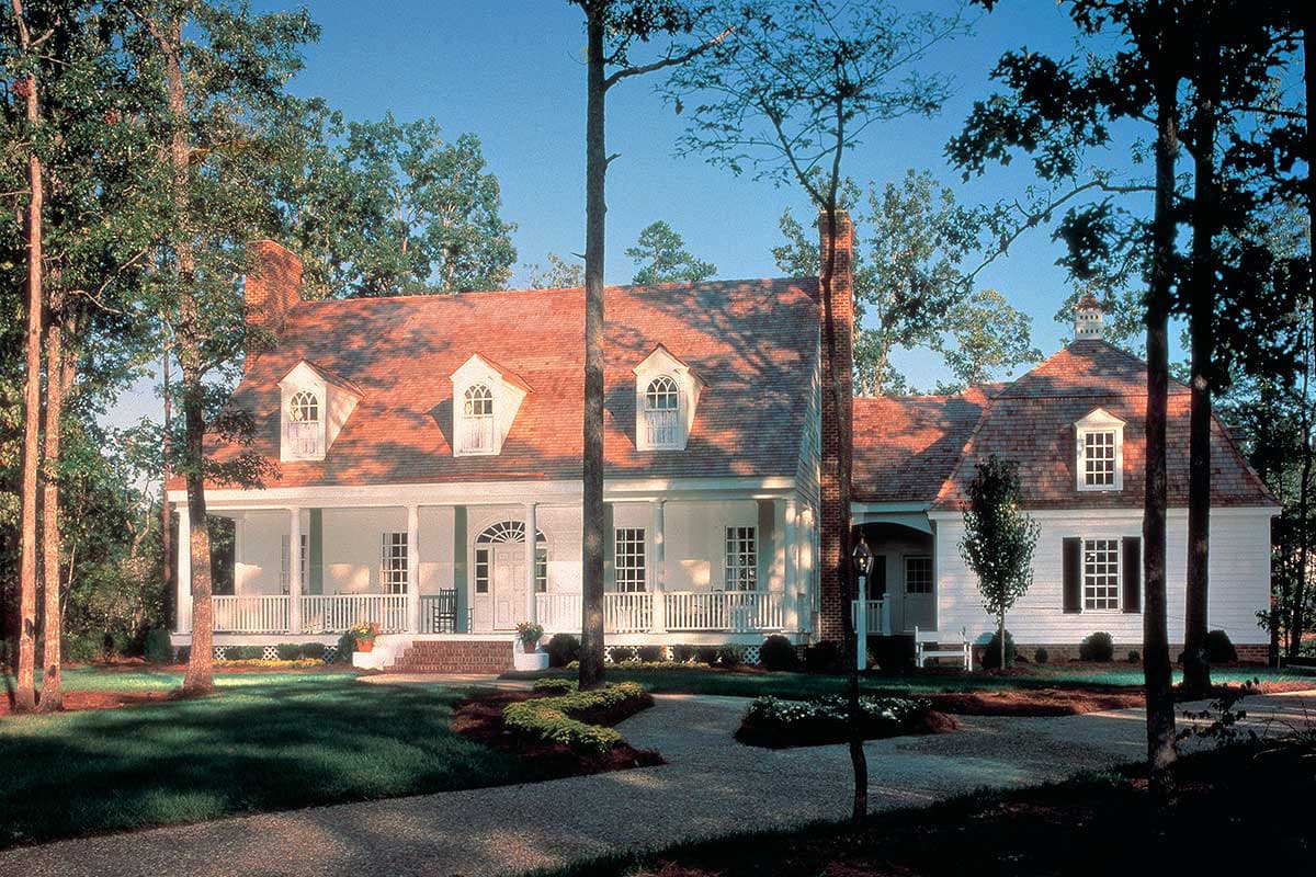 House plan exterior: Two-story, white siding home with a wrap-around porch, dormers, and a brick chimney.