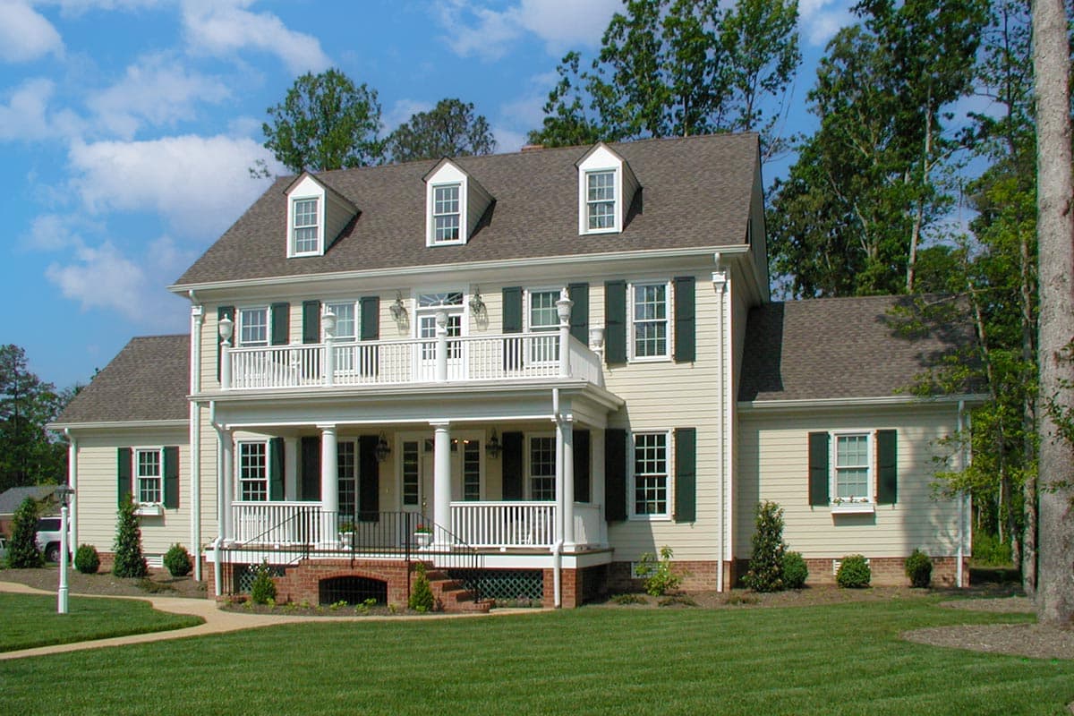 Two-story Traditional house plan exterior with dormers, a wraparound porch, and a second-story balcony.