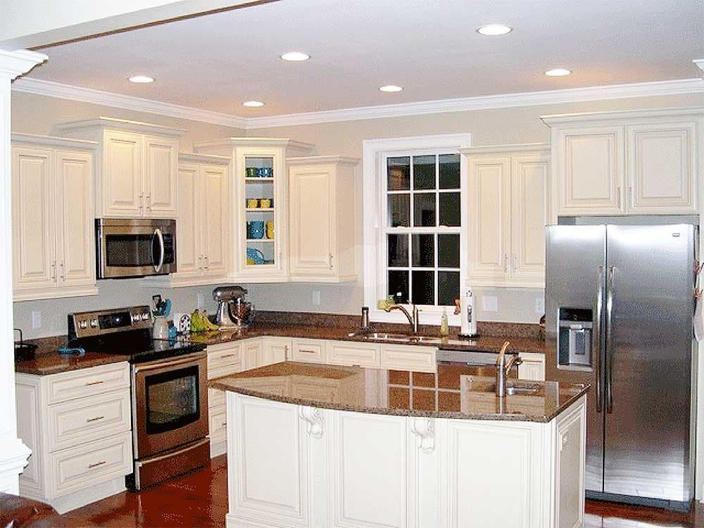 Kitchen with white cabinetry, granite countertops, stainless steel appliances including a refrigerator, range, and microwave, and a central island.
