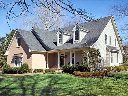 House plan exterior featuring a complex roofline with dormers, a covered front porch, and brick and siding facade.