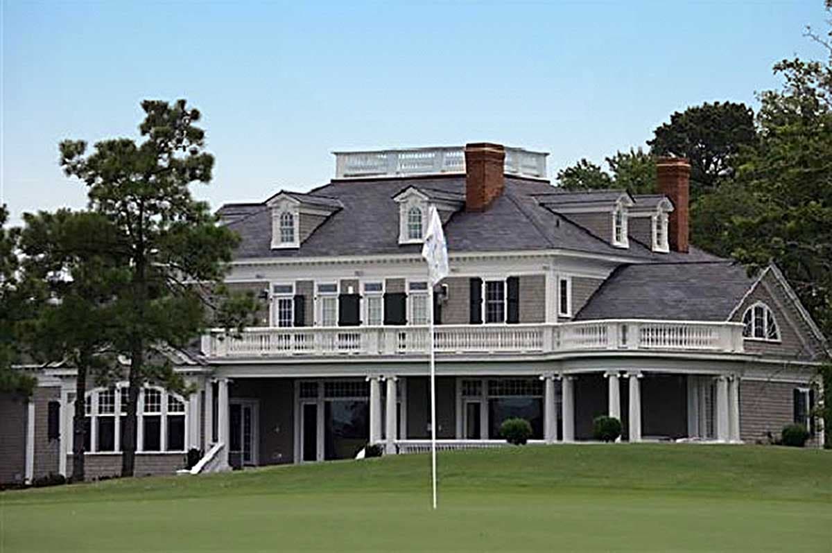 House plan exterior: Two-story Colonial Revival with prominent wrap-around porch, dormers, and gambrel rooflines.