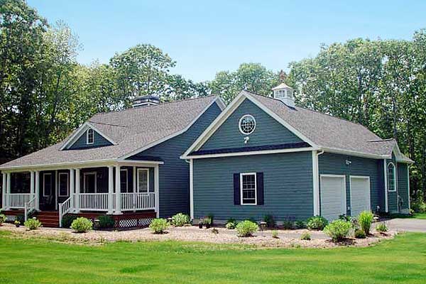 House plan exterior: One-story home with wraparound porch, gables, dormers, and a two-car garage.