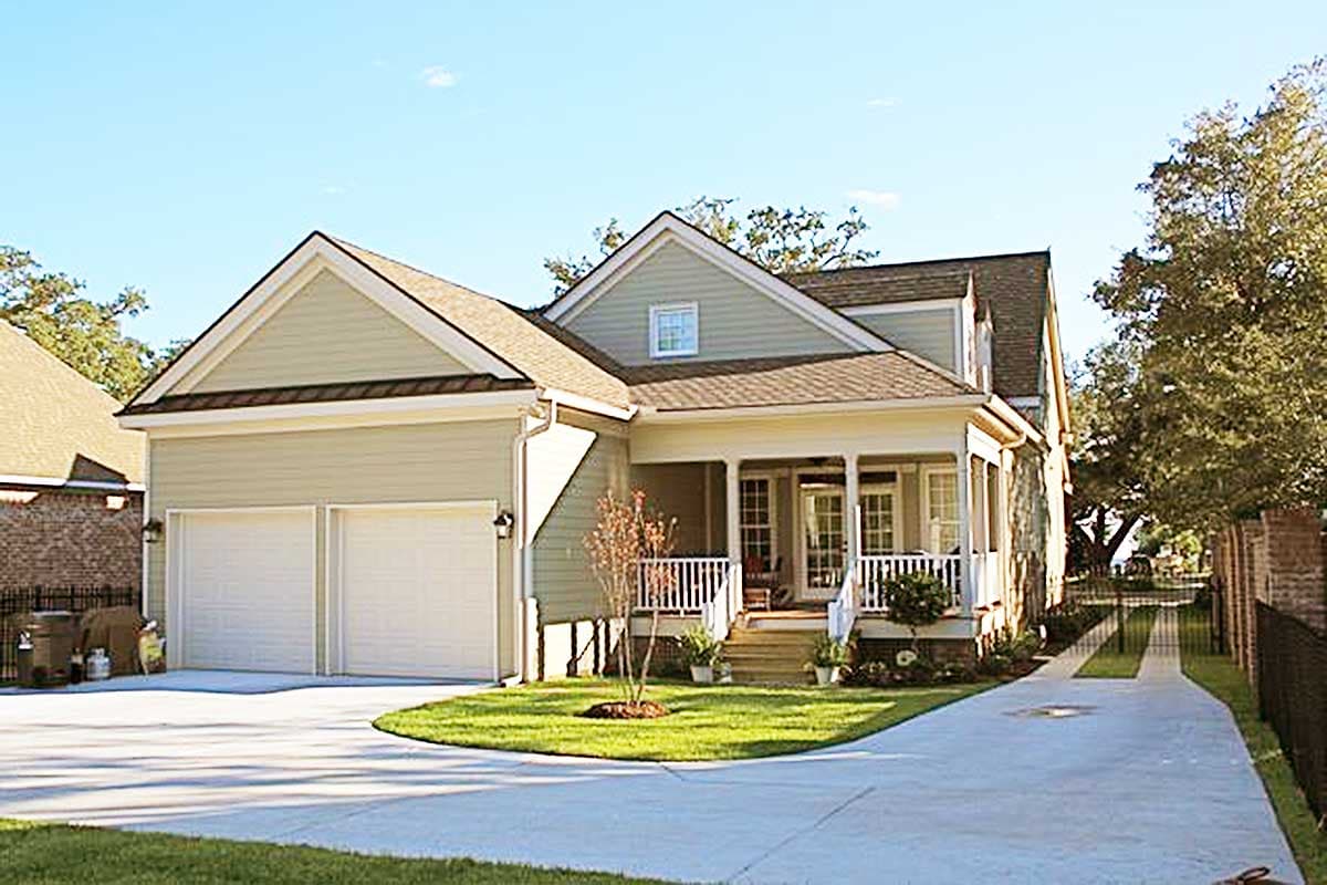Two-story house plan exterior with a front porch, gable rooflines, and a side-entry two-car garage.