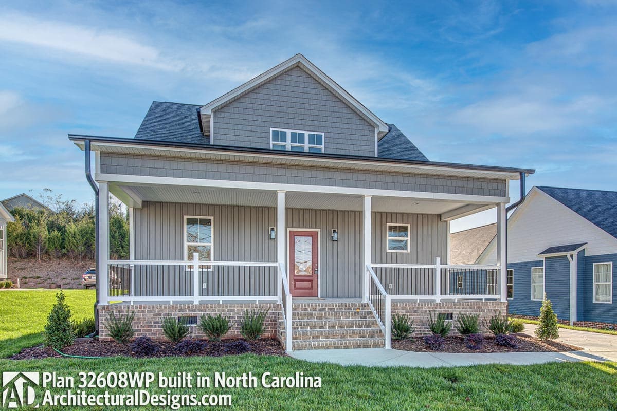 House plan exterior with a wide front porch, gabled dormer, and stacked brick foundation.