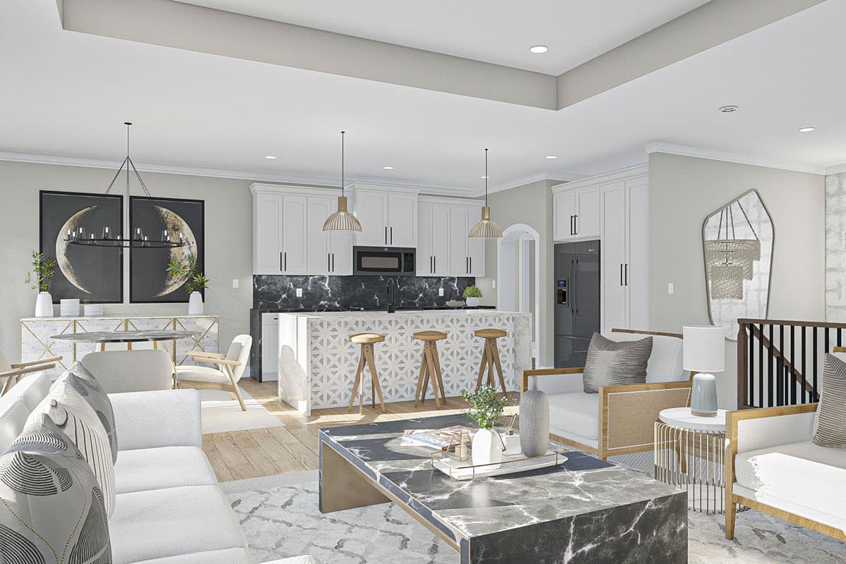 Open concept living and kitchen area with island seating, white cabinetry, modern furniture, and decorative wall art.