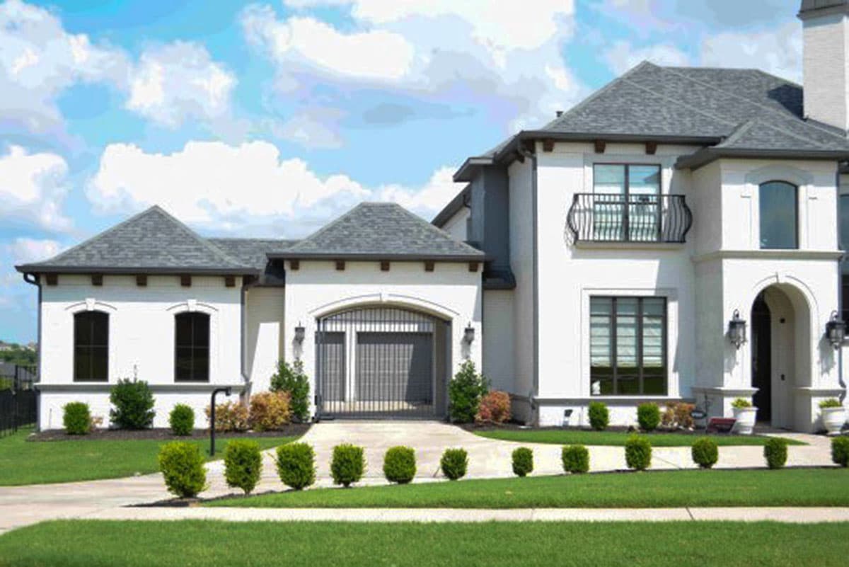 House plan exterior: Two-story, stucco home with a stucco facade, arched garage entry, and a second-story balcony.