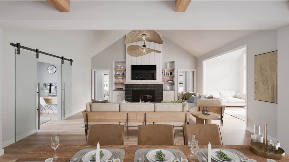 Living room with vaulted ceiling, fireplace, built-in shelving, and glass sliding doors.