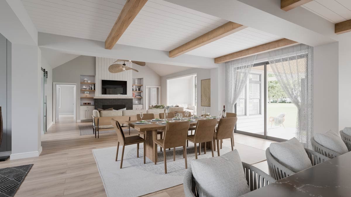Open concept living space with vaulted beamed ceiling, dining table, fireplace, and large windows.
