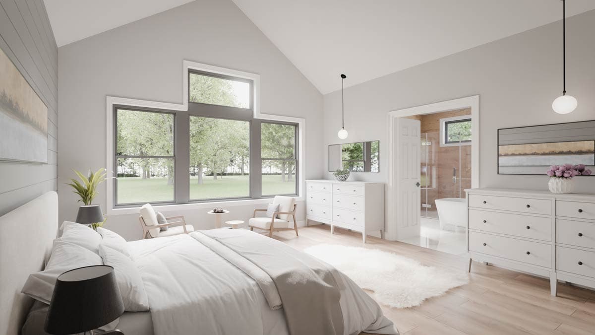 Bedroom with vaulted ceiling, large windows, and adjacent bathroom with freestanding tub.