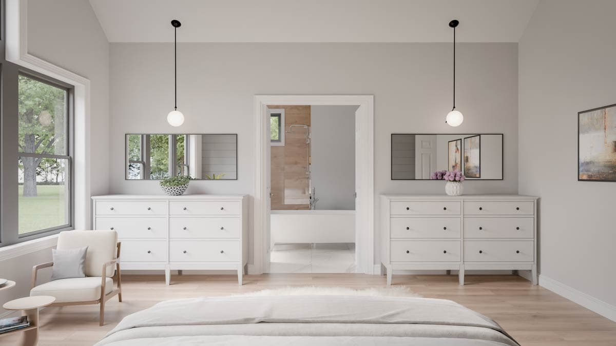 Primary suite with two dressers, armchair, and view into ensuite bathroom with soaking tub and shower.